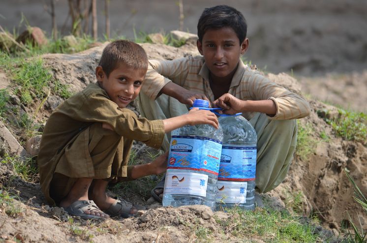 Zwei Jungen mit Wasserkanistern