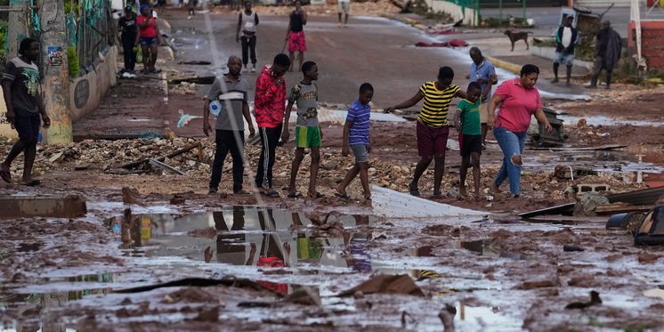 Menschen gehen durch die Straßen von Santa Cruz auf Jamaika, die nach Hurrikan Melissa verwüstet wurden.