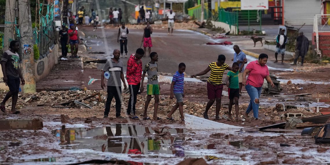 Menschen gehen durch die Straßen von Santa Cruz auf Jamaika, die nach Hurrikan Melissa verwüstet wurden.